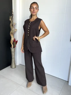 Conjunto de mujer con chaleco largo marrón chocolate sin mangas y botones dorados, combinado con pantalón ancho.