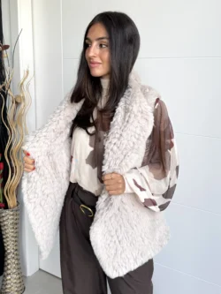 Mujer luciendo chaleco de pelo sintético beige claro, detalle de frente a media altura.