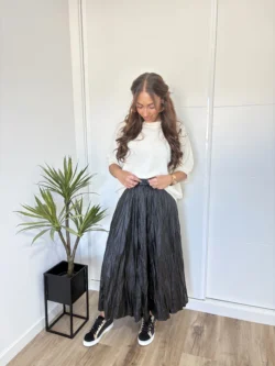 Conjunto con falda midi polipiel negra y jersey blanco oversize.