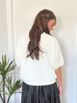 Jersey blanco básico de punto con manga caída y brillo sutil.