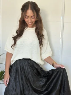 Jersey blanco de mujer con diseño relajado y manga caída.