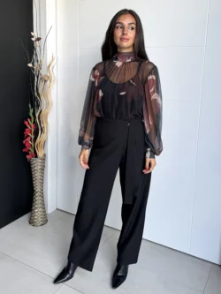 Modelo de frente con pantalón negro de tiro alto cruzado y pierna