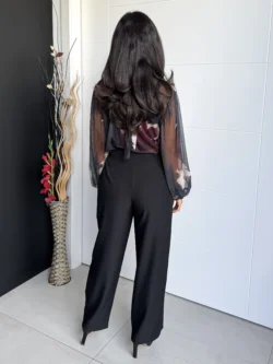 Modelo de espaldas luciendo pantalón negro de vestir tiro alto.