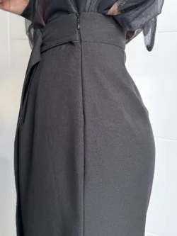 Lateral de pantalón negro de tiro alto con cierre.