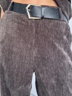 Pantalón de terciopelo marrón tiro medio con cinturilla y cinturón negro.