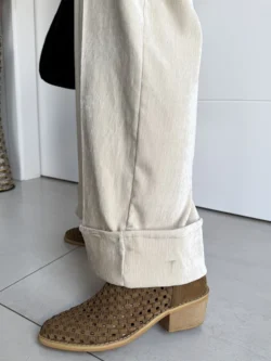 Detalle bajo pantalón ancho beige con dobladillo vuelto