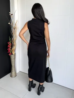 Mujer con vestido negro midi entallado, vista de espalda.