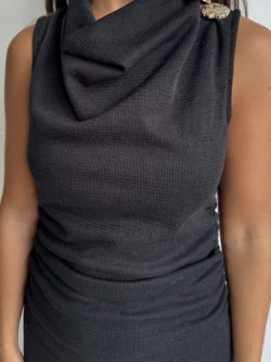 Primer plano del cuello drapeado del vestido negro midi.